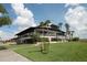 Exterior view of the clubhouse featuring a modern design, lots of windows, and well-manicured landscaping at 515 Cassandra Ln, Lakeland, FL 33809