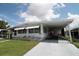 Charming mobile home featuring white siding, awnings, covered parking, and landscaped front yard at 515 Cassandra Ln, Lakeland, FL 33809