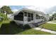 Exterior side view of the home with a porch, plants, and a landscaped yard at 515 Cassandra Ln, Lakeland, FL 33809
