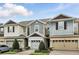 Exterior shot of townhomes featuring attached garages, neutral colors, and well-maintained landscaping at 1143 Presidential Ln, Apopka, FL 32703