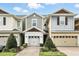 Charming two-story townhome featuring an attached garage and a manicured front yard at 1143 Presidential Ln, Apopka, FL 32703