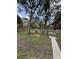 Spacious backyard featuring mature trees, landscaping, and a seating area at 204 Madison St, Minneola, FL 34715