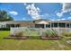 Well maintained lawn features a patio umbrella and a white picket fence at 4711 Club Cir, Lakeshore, FL 33854