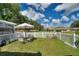 Lush backyard with manicured lawn, seating area, and white picket fence at 4711 Club Cir, Lakeshore, FL 33854