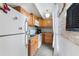 Efficient kitchen featuring wood cabinets, white appliances, and a stylish backsplash at 4711 Club Cir, Lakeshore, FL 33854
