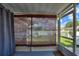 Screened-in porch provides outdoor seating with view of white picket fence at 4711 Club Cir, Lakeshore, FL 33854