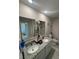 Elegant bathroom featuring double sinks, a granite countertop, and modern fixtures, creating a luxurious space at 10090 Se 67Th Ter, Belleview, FL 34420