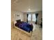 Bedroom featuring marble tile flooring, two windows, and modern decor at 10090 Se 67Th Ter, Belleview, FL 34420