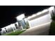 Single-Gathering home with an attached garage, featuring bright exterior lighting at 10090 Se 67Th Ter, Belleview, FL 34420