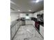 Bright kitchen featuring white cabinets, granite countertops, and marble tile flooring at 10090 Se 67Th Ter, Belleview, FL 34420