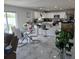 Open concept living area with marble floors, modern furnishings and eat-in kitchen at 10090 Se 67Th Ter, Belleview, FL 34420