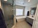 Luxurious bathroom with a soaking tub, glass-enclosed shower, and modern vanity at 13774 Meadowpark Ave, Orlando, FL 32826
