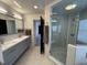 Elegant bathroom features a glass enclosed shower and dual sink vanity with grey cabinets at 13774 Meadowpark Ave, Orlando, FL 32826