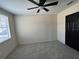 Bedroom features plush carpet, a ceiling fan, and closet with a view from the window at 13774 Meadowpark Ave, Orlando, FL 32826