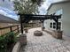 Beautiful backyard patio with a custom brick fire pit, curved benches, and a pergola with string lights at 13774 Meadowpark Ave, Orlando, FL 32826