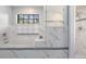 Modern bathroom featuring a soaking tub and a glass-enclosed shower with marble-style tiling and natural light at 2925 Deerbrook Dr, Lakeland, FL 33811