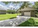 Attached garage and adjacent covered patio and backyard, set against a backdrop of well-manicured lawn and mature trees at 2925 Deerbrook Dr, Lakeland, FL 33811