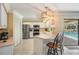 Well-lit kitchen featuring white cabinets, stainless steel appliances, tile floors and pool access at 2925 Deerbrook Dr, Lakeland, FL 33811