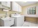 Functional laundry room with a utility sink, washer, dryer, and ample cabinet space for storage and organization at 2925 Deerbrook Dr, Lakeland, FL 33811