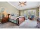 Tranquil main bedroom featuring a bay window, ceiling fan, and a king-size bed with decorative pillows at 2925 Deerbrook Dr, Lakeland, FL 33811