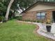 Exterior featuring a brick facade, garden beds, and a well-maintained lawn, showcasing the property's curb appeal at 909 Heatherbrook Dr, Auburndale, FL 33823