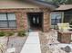 Welcoming home entrance with brick facade, landscaped yard, swing, and a charming walkway at 909 Heatherbrook Dr, Auburndale, FL 33823