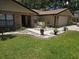 Charming home featuring a manicured lawn, brick accents, and a welcoming walkway with a swing and potted plants at 909 Heatherbrook Dr, Auburndale, FL 33823