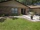 Charming home featuring a manicured lawn, brick accents, and a welcoming walkway with a swing and potted plants at 909 Heatherbrook Dr, Auburndale, FL 33823