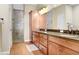 Bathroom featuring double sinks, granite countertops, wood cabinets, and walk-in shower at 93 Bream St, Haines City, FL 33844