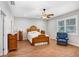 Comfortable bedroom with ceiling fan, hardwood floors, and a cozy armchair by the window at 93 Bream St, Haines City, FL 33844