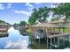 Scenic view of a waterfront property featuring a covered dock with a boat lift and tranquil water views at 93 Bream St, Haines City, FL 33844