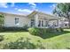 The exterior shows a well-maintained lawn, lush garden, and a covered patio for outdoor enjoyment at 93 Bream St, Haines City, FL 33844