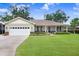Charming single-story home featuring a well-manicured lawn, attached garage, and covered front porch at 93 Bream St, Haines City, FL 33844