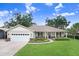 Charming single-story home featuring a well-manicured lawn, attached two-car garage and inviting front porch at 93 Bream St, Haines City, FL 33844
