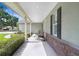 Spacious, covered porch with stone accents, offering a relaxing outdoor space and views of the landscaped yard at 93 Bream St, Haines City, FL 33844