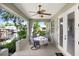 Covered patio featuring a ceiling fan, outdoor seating, and lush landscaping overlooking the canal at 93 Bream St, Haines City, FL 33844