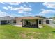 Lush green backyard with a screened lanai and patio area, ideal for outdoor entertaining at 1032 Kelsea Cir, The Villages, FL 32159