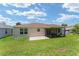 Spacious backyard with green lawn, patio, and a screened-in porch at 1032 Kelsea Cir, The Villages, FL 32159
