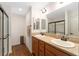 Bathroom featuring double sinks, wood-look flooring and a walk-in shower with modern fixtures at 1032 Kelsea Cir, The Villages, FL 32159