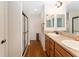 Bathroom featuring double sinks, shower and wood-look vinyl flooring at 1032 Kelsea Cir, The Villages, FL 32159