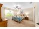 Comfortable bedroom with a ceiling fan, large window for natural light, and neutral carpeting at 1032 Kelsea Cir, The Villages, FL 32159