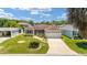 Inviting single-story home featuring a manicured lawn, charming landscaping, and attached garage at 1032 Kelsea Cir, The Villages, FL 32159