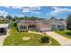 Charming home with a lush front lawn, beautiful landscaping, and an attached two-car garage at 1032 Kelsea Cir, The Villages, FL 32159