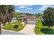 Inviting single-story home featuring a manicured lawn, charming landscaping, and attached garage at 1032 Kelsea Cir, The Villages, FL 32159