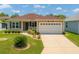 Charming single-story home featuring a well-maintained lawn and a two-car garage at 1032 Kelsea Cir, The Villages, FL 32159