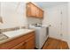 Laundry room features washer, dryer, sink, and wooden cabinets offering ample storage space at 1032 Kelsea Cir, The Villages, FL 32159
