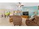 Bright living room featuring comfortable seating, ceiling fan, and adjacent kitchen and dining areas at 1032 Kelsea Cir, The Villages, FL 32159