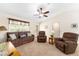 Inviting living room featuring three recliners, a ceiling fan, and ample natural light at 1032 Kelsea Cir, The Villages, FL 32159
