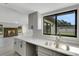 Modern kitchen showcases gray cabinetry, quartz countertops, and stainless steel sink overlooking the backyard at 2151 Groveglen S Ln, Lakeland, FL 33813