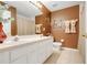 Traditional bathroom with double sinks, decorative accents, and neutral tile flooring at 2256 Wekiva Village Ln, Apopka, FL 32703